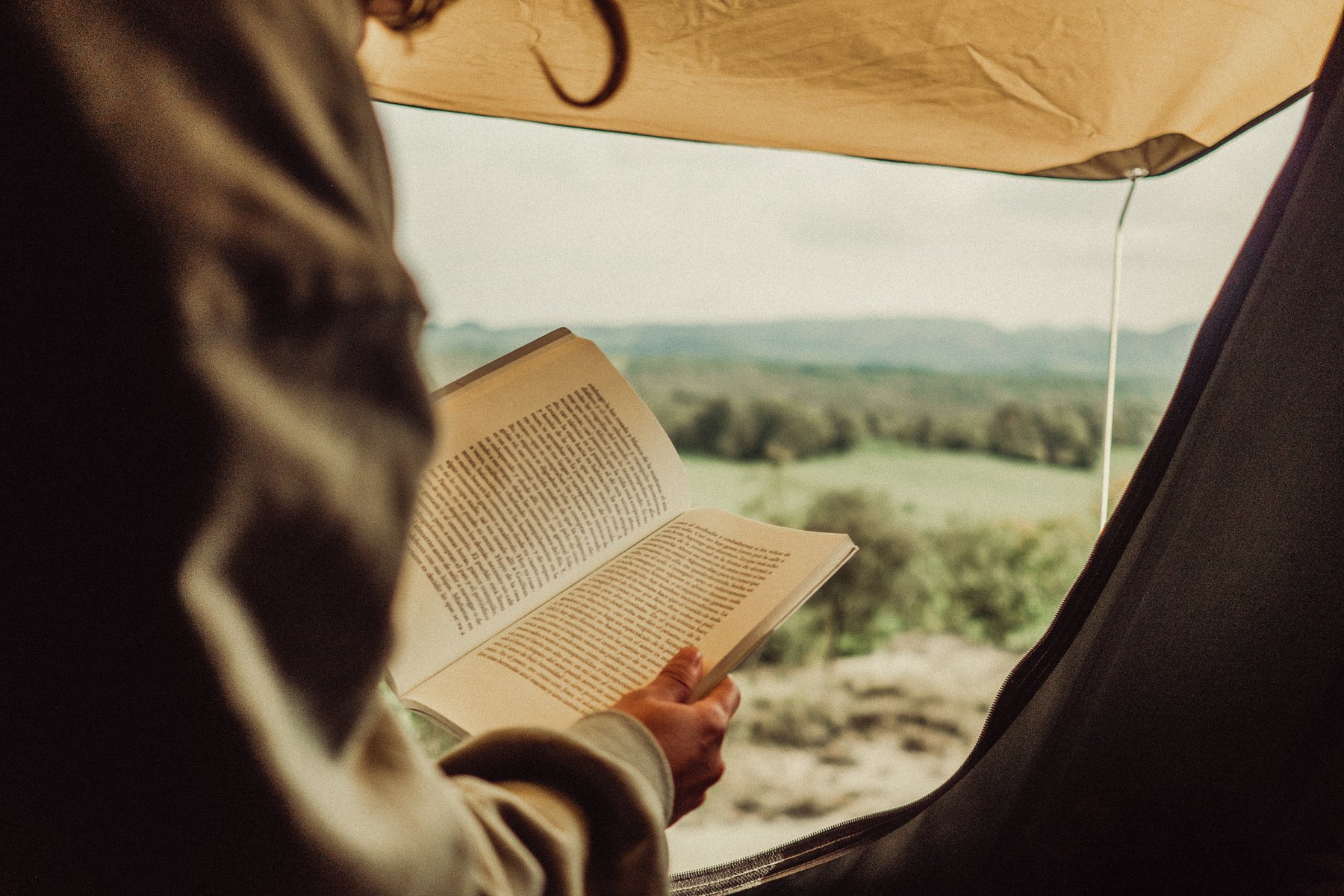 Person Reading Book in Tent